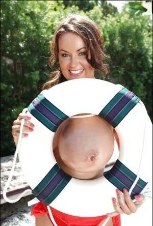 Big tit model Sarah Nicola Randall flaunting her oiled juggs outdoors on tubephoto.pics