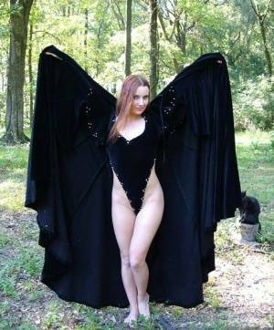 Redhead amateur Amber Lily models nude in a forest draped in a black cape on tubephoto.pics