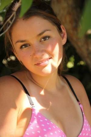 Petite amateur Allie Haze shows her tan lined body in the shade of a tree on tubephoto.pics