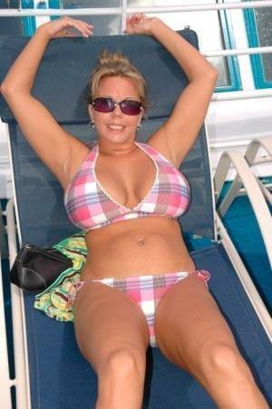 Hugely busty Amber Lynn Bach doffs her bikini to spread her legs wide nude on tubephoto.pics