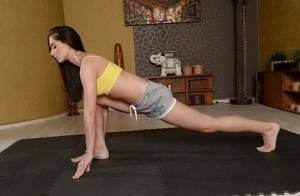 Cute brunette babe Aruna Aghora doing yoga in shorts and bare feet on tubephoto.pics