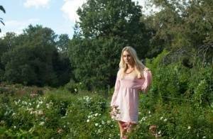Dirty blonde Dolly touches her hairy teen pussy with a white rose on a lawn on tubephoto.pics
