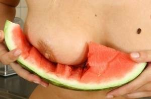 Blonde vixen Flower undressing in the kitchen to eat melon with bare big tits on tubephoto.pics
