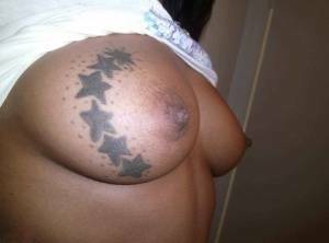 Ebony amateur takes self shots of her big tattooed boobs and bald vagina on tubephoto.pics
